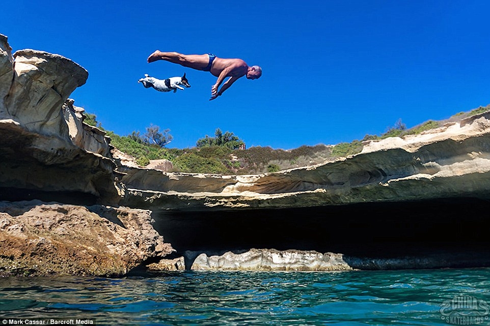 A man and his pet dog in Malta perform a hilarious synchronized dive while swimming at a local water hole on the island