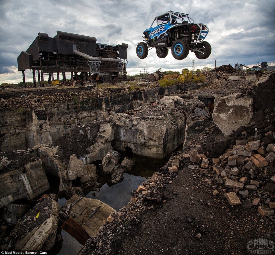 A turbocharged off-road vehicle performs a death-defying leap through the second storey of a derelict building